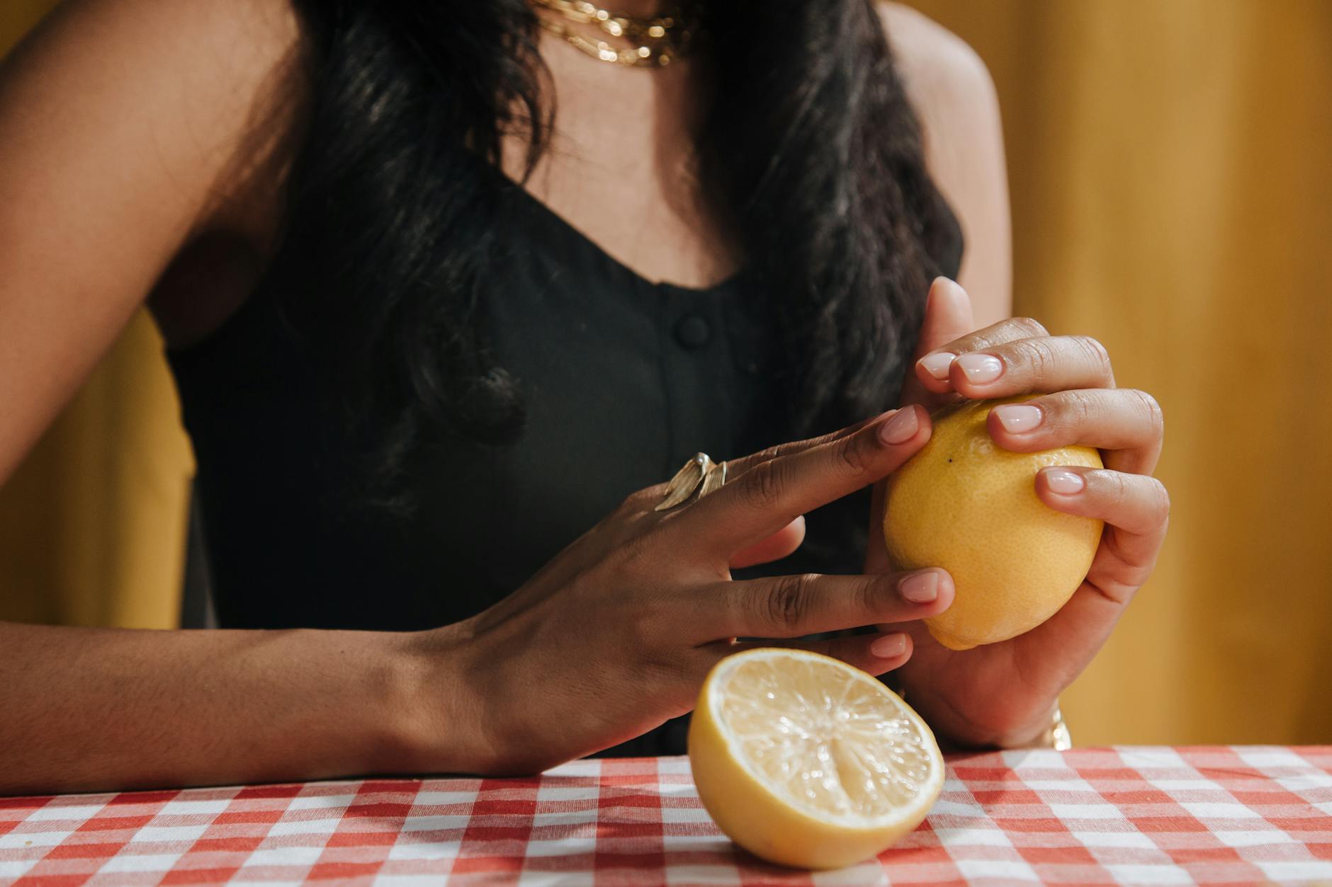 Eine Hand hält einen modernen Zitronenvibrator gegen einen minimalistischen Hintergrund, symbolisierend Intimität nach langer Partnerschaft